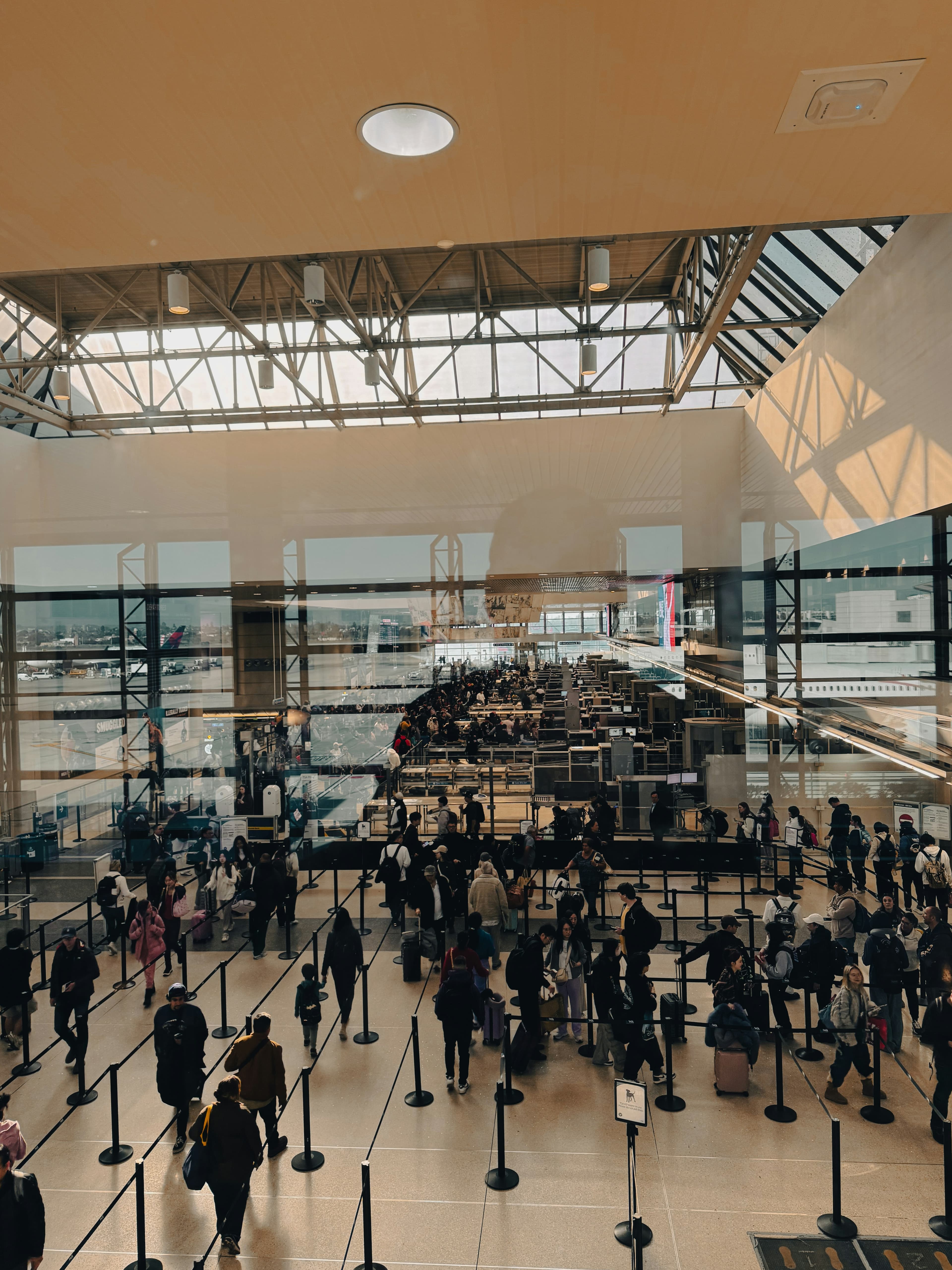 Lines of flyers waiting at an airport TSA checkpoint with their luggage