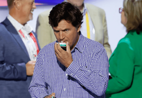 Tucker Carlson holding a tin of nicotine pouches